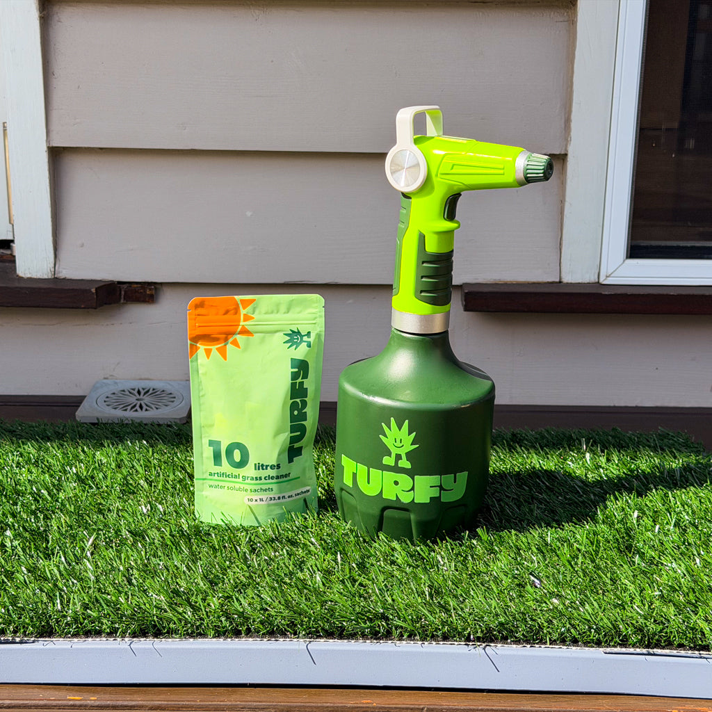 Green turf care product with a enzyme cleaner refill pouch and electric sprayer on artificial grass

