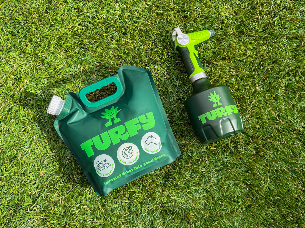 Turfy probiotic artificial grass cleaner showing 2.5 litre pouch and 1 litre bottle laying flat on fake grass.